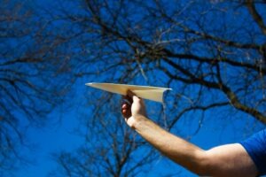 holding a paper airplane
