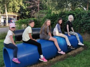 5 Cub scouts sitting on a barrel